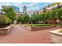 Beautifully landscaped courtyard with vibrant flowers and brick pathways at 300 W 5Th St # 136, Charlotte, NC 28202