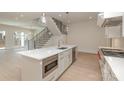 Open kitchen featuring stainless steel appliances, modern island and connecting staircase at 3131 Providence Rd # 1B, Charlotte, NC 28211