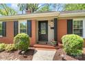 A cozy brick home entrance with black shutters and well-manicured landscaping at 4626 Fairbluff Pl, Charlotte, NC 28209