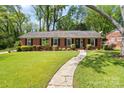 Charming brick home with a manicured front yard, walkway and mature trees at 4626 Fairbluff Pl, Charlotte, NC 28209