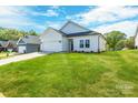 Attractive single-Gathering home featuring green grass, and an attached two-car garage with a concrete driveway at 540 Church St, Locust, NC 28097