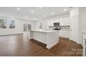 Open-concept kitchen with a large island, white cabinets, stainless steel appliances, and hardwood floors at 562 Mountain View Dr, Monroe, NC 28110