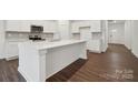 Bright kitchen with white cabinets, quartz countertops, stainless appliances, and a spacious center island at 562 Mountain View Dr, Monroe, NC 28110