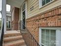 Inviting entryway with brick accents, decorative door wreath, and black iron railings, showcasing classic charm at 668 Sixth Baxter Xing, Fort Mill, SC 29708