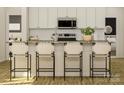 Modern kitchen featuring white cabinets, a stainless steel microwave, and a center island with bar stool seating at 8432 Norman Forest Rd, Lancaster, SC 29720