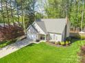 Overhead view of a charming house boasting a manicured lawn and a private driveway in a wooded neighborhood at 8707 Copenhagen Ln, Charlotte, NC 28216