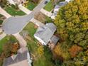 An aerial view of a home with a backyard patio area surrounded by lush, mature trees at 8929 Lizzie Ln, Huntersville, NC 28078