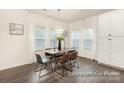 Dining room with a modern chandelier, wood table, chairs, large windows, and sleek flooring at 908 Cypress Point Ln # 218, Monroe, NC 28112