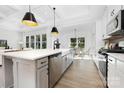 Bright, modern kitchen boasts stainless steel appliances, quartz countertops, and island with pendant lighting at 908 Cypress Point Ln # 218, Monroe, NC 28112