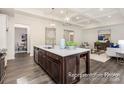Spacious open-concept kitchen with a large island, white countertops, stainless steel appliances, and wood floors at 908 Cypress Point Ln # 218, Monroe, NC 28112