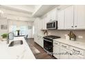 Bright kitchen featuring white cabinets, countertops, a modern backsplash, and stainless steel appliances at 908 Cypress Point Ln # 218, Monroe, NC 28112