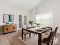 Elegant dining area with stylish table, chairs, modern light fixture, and convenient access to outdoor area at 105 Tanner Loop, Troutman, NC 28166