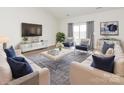 Bright living room with neutral decor, large windows, and modern furnishings offers a welcoming space at 105 Tanner Loop, Troutman, NC 28166
