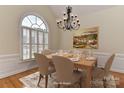 Elegant dining room features a large arched window, stylish chandelier, and ample seating for formal gatherings at 1090 Heather Glen Dr, Matthews, NC 28104