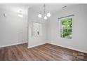 Bright dining room featuring hardwood floors, a window, and an open layout at 11040 E Lake Rd, Charlotte, NC 28215