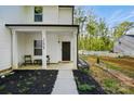 Inviting front porch with a seating area, manicured flowerbeds and stepping stone path at 11040 E Lake Rd, Charlotte, NC 28215