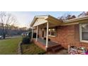 This cozy brick home has a covered front porch with white columns and trim at 124 Riley Rd, Dallas, NC 28034