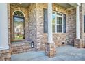 Inviting brick porch with classic columns and decorative shutters for enhanced curb appeal at 133 Misty Woods Dr, Lake Wylie, SC 29710