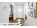Bright entryway featuring hardwood floors, modern decor, and a view of the front door at 1332 Secrest Commons Dr, Monroe, NC 28112