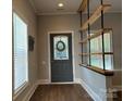 Welcoming entryway featuring a decorative front door, stylish wood floors, and unique shelving at 179 Tomahawk Ln, Mount Gilead, NC 27371