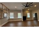 Open-concept living room with wood floors, large windows, and custom shelving, perfect for entertaining at 179 Tomahawk Ln, Mount Gilead, NC 27371