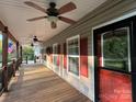 Inviting covered porch featuring ceiling fans and classic red shutters, providing a comfortable outdoor space at 179 Tomahawk Ln, Mount Gilead, NC 27371