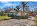 This single-story home features a brick chimney and a spacious backyard with mature trees at 21 W D St, Newton, NC 28658