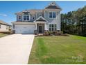 Stylish two-story house boasts a large driveway, manicured lawn, and inviting curb appeal under a bright, sunny sky at 2108 Sabra St, Gastonia, NC 28054