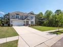 Charming two-story home features a spacious driveway and well-manicured lawn, surrounded by lush trees and clear blue skies at 2108 Sabra St, Gastonia, NC 28054