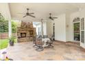 Covered patio with stone fireplace, ceiling fans, and a dining table and chairs at 212 Horn Tassel Ct, Indian Trail, NC 28079