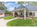Spacious backyard featuring an outdoor fireplace, covered patio with ceiling fans and a grassy area at 212 Horn Tassel Ct, Indian Trail, NC 28079