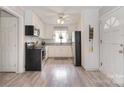 White kitchen with stainless steel appliances, patterned backsplash, and hardwood floors at 2825 Old Pageland Marshville Rd, Wingate, NC 28174