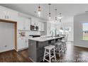 Modern kitchen with white cabinets, subway tile backsplash, island with bar seating, and stainless appliances at 36131 Greg Norman Dr # 1031, Lancaster, SC 29720