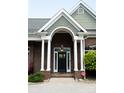 Close-up view of the front door entrance, featuring white columns and a black door with sidelights at 447 Shagbark Ct, Mount Gilead, NC 27306
