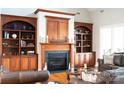 Elegant living room featuring a fireplace with built-in bookshelves and comfortable leather furniture at 447 Shagbark Ct, Mount Gilead, NC 27306