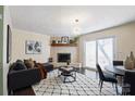 Cozy living room with a brick fireplace, dark wood floors, and a modern light fixture at 507 Texas Trl, Dallas, NC 28034