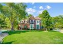 Attractive two-story brick home with a manicured front yard and vibrant green trees at 62 Pond View Ln, Fort Mill, SC 29715