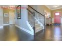 Inviting entryway featuring hardwood floors, a staircase with wooden railing, and a front door at 7023 Butternut Oak Ter, Huntersville, NC 28078