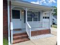 Inviting front porch featuring white railings, brick accents, decorative wreath, and exterior lighting at 715 Cody Ct, Fort Mill, SC 29715