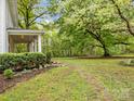 A large, green backyard with a stone path, lush trees, and beautiful landscaping at 740 Woodlawn Ave, Mount Holly, NC 28120