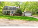 Charming two-story home featuring a well-kept lawn, a detached garage, and verdant surrounding foliage at 7514 Pewter Ln, Charlotte, NC 28270