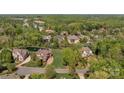 An aerial view of a neighborhood highlighting mature trees, lush lawns, a community pond and stately homes at 8100 Skye Knoll Dr # 144, Waxhaw, NC 28173