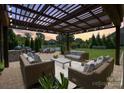 Inviting outdoor living space features a covered patio with comfortable seating overlooking a serene pond at 9611 Pensive Ln, Waxhaw, NC 28173