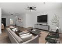Open-concept living room with modern furniture, ceiling fan, and view of the stairs at 1041 Secor St, Statesville, NC 28677