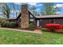 Close-up of single-story home's front entrance with stone chimney and manicured lawn at 1074 Oakridge Farm Hwy, Mooresville, NC 28115