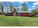 Charming single-story home featuring a stone chimney and well-maintained landscaping at 1074 Oakridge Farm Hwy, Mooresville, NC 28115