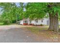 Lovely single-story home with a well-maintained front yard and a gravel driveway, shaded by mature trees at 1116 Montgomery Ave, Albemarle, NC 28001
