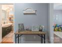 Hallway with a view of a bathroom and a playroom, featuring a wooden table and decorative items at 1116 Montgomery Ave, Albemarle, NC 28001