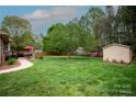 Lush backyard with patio, storage shed and mature trees, providing a serene outdoor space at 115 Stumpy Creek Rd, Mooresville, NC 28117