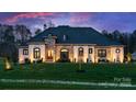 Stunning home exterior with stone accents, manicured lawn, and professional landscaping at 129 Hunts Landing Dr, Mooresville, NC 28117